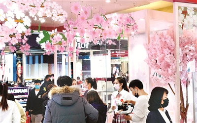 图为辽宁沈阳一商场为迎接顾客用各种花卉装扮内景。顾客宛如进入一个大花园，挑选自己喜欢的商品。 （图片来源：视觉中国）