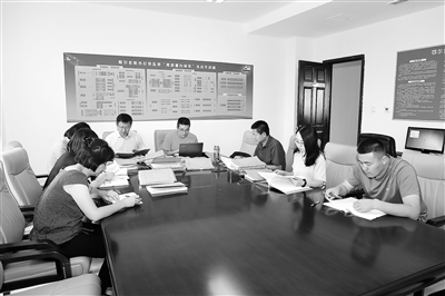 图为鄂尔多斯市纪委监委办案人员在分析讨论姜惠君案案情。赵鹏 摄