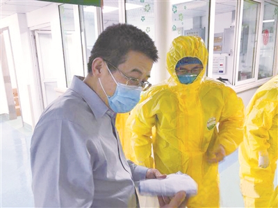 图为疫情期间，邱海波（左一）在武汉金银潭医院巡诊。 （资料图片）