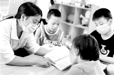 图为近日，一位社工（左一）在灵山县儿童福利院内为孩子们读书。 新华社记者 张玉薇 摄