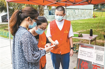 面对疫情防控严峻形势，福建省厦门市纪检监察干部在积极开展监督检查的同时，组成志愿服务队分赴抗疫一线开展志愿服务活动。图为9月13日，当地纪检监察干部在厦门软件园主要出入口测量体温、核实信息。杨玥 摄