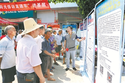 江西省宜黄县纪委监委把惩治基层“微腐败”同扫黑除恶专项斗争结合起来，严查黑恶势力背后的“保护伞”。图为近日该县纪检监察干部向群众讲解涉黑涉恶典型案例和举报公告。 李明珠 摄